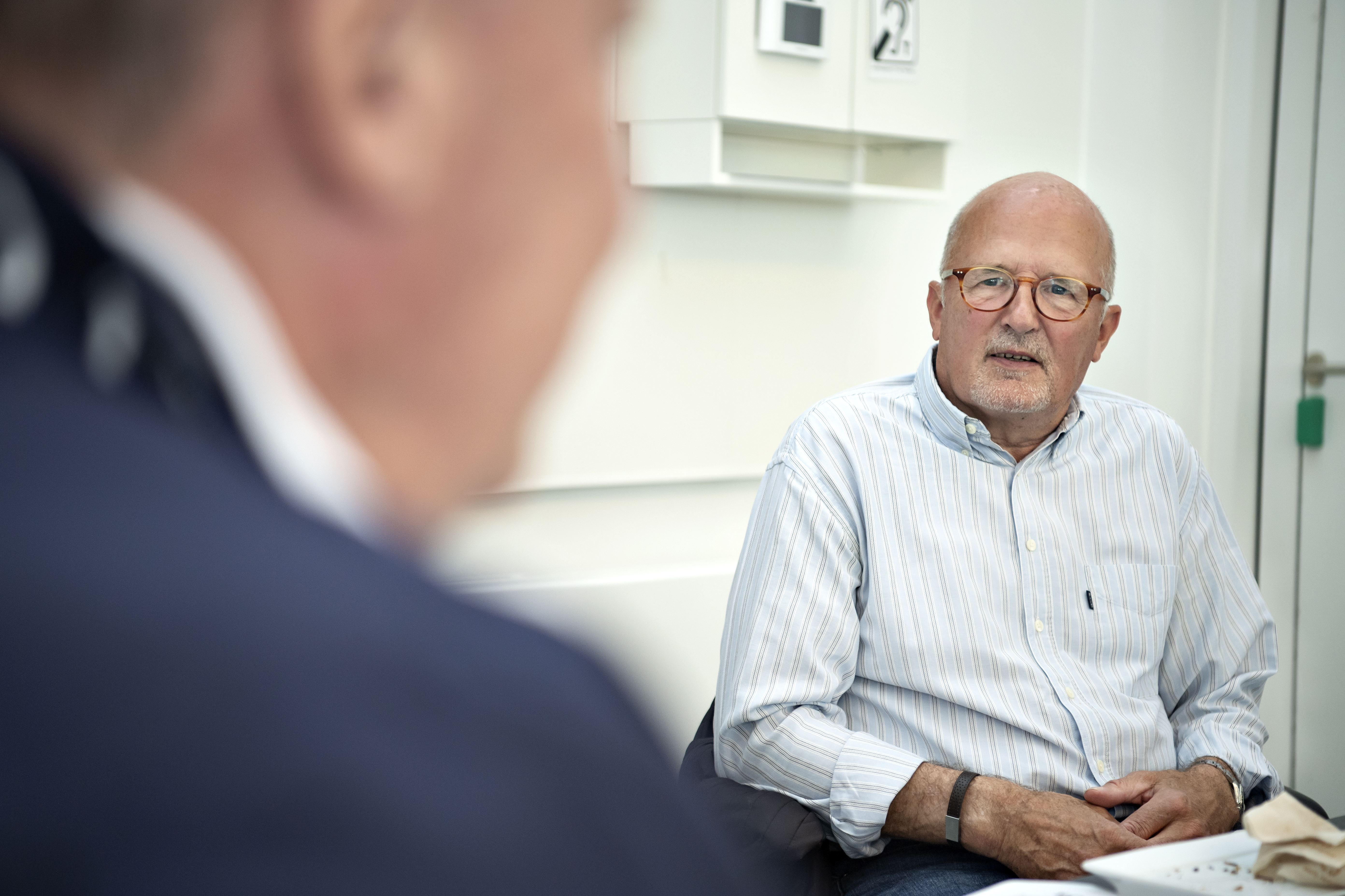 To personer sidder og taler sammen