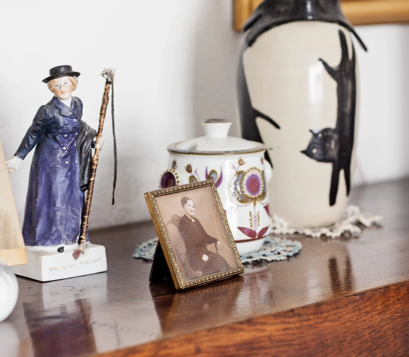 Porcelaensfigur og -skål og et billede, som er udstillet på Anna Margrete Jensens kommode.