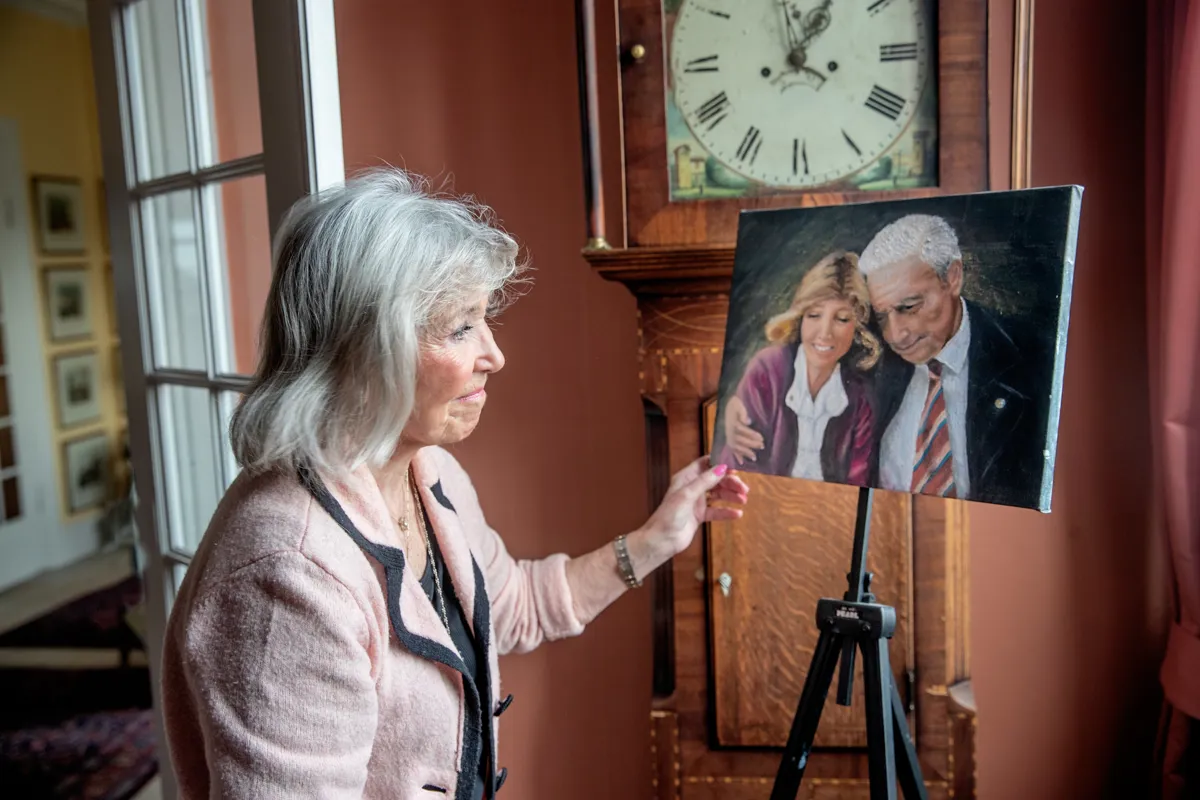Kvinde kigger på portraet af sig selv og en mand