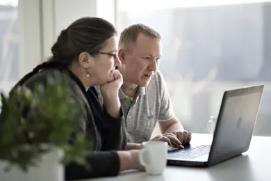 Mand og kvinde sidder foran computer