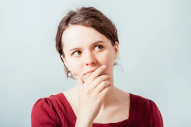 En kvinde undrer sig og tænker over noget.