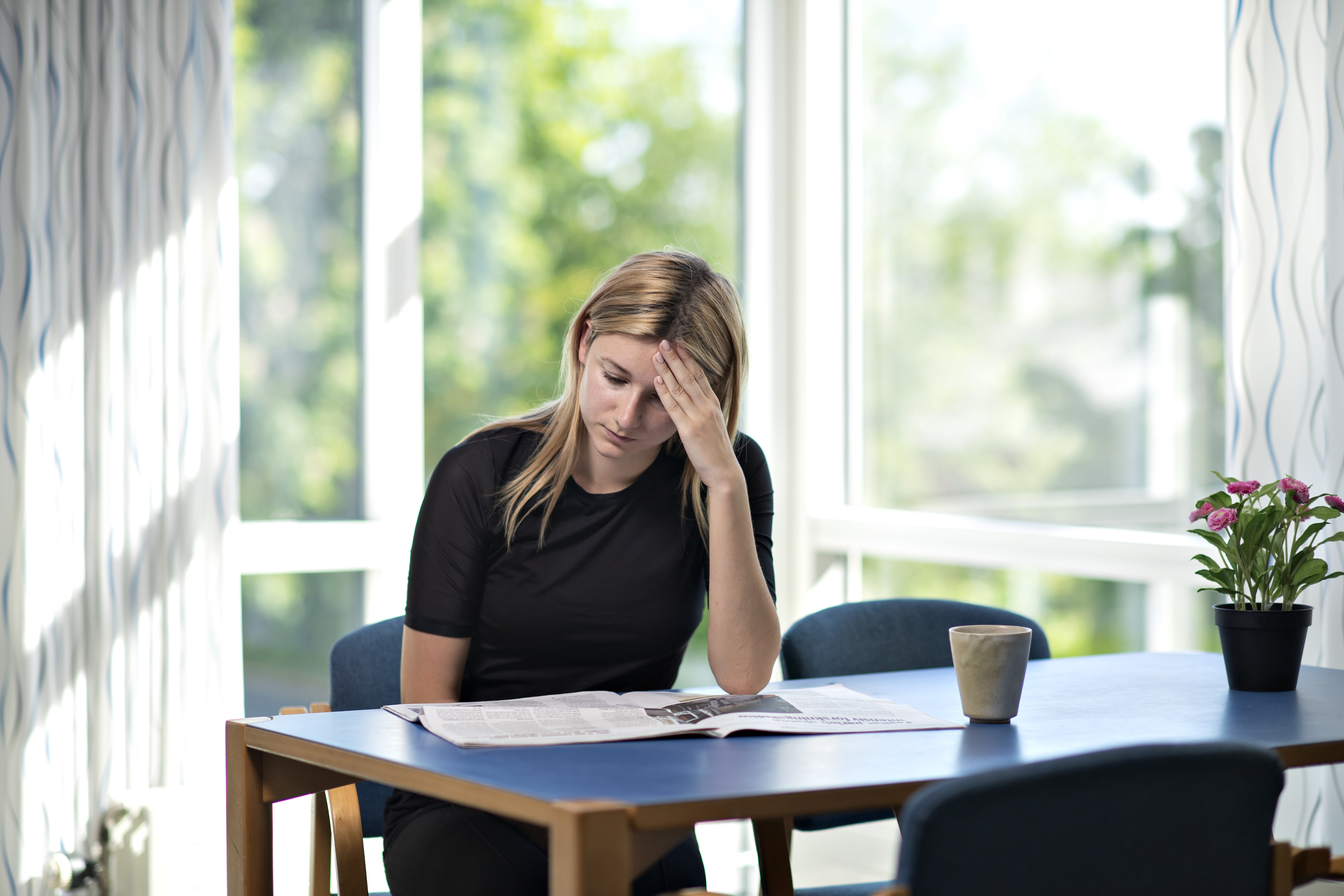 En kvinde sidder og laeser en avis