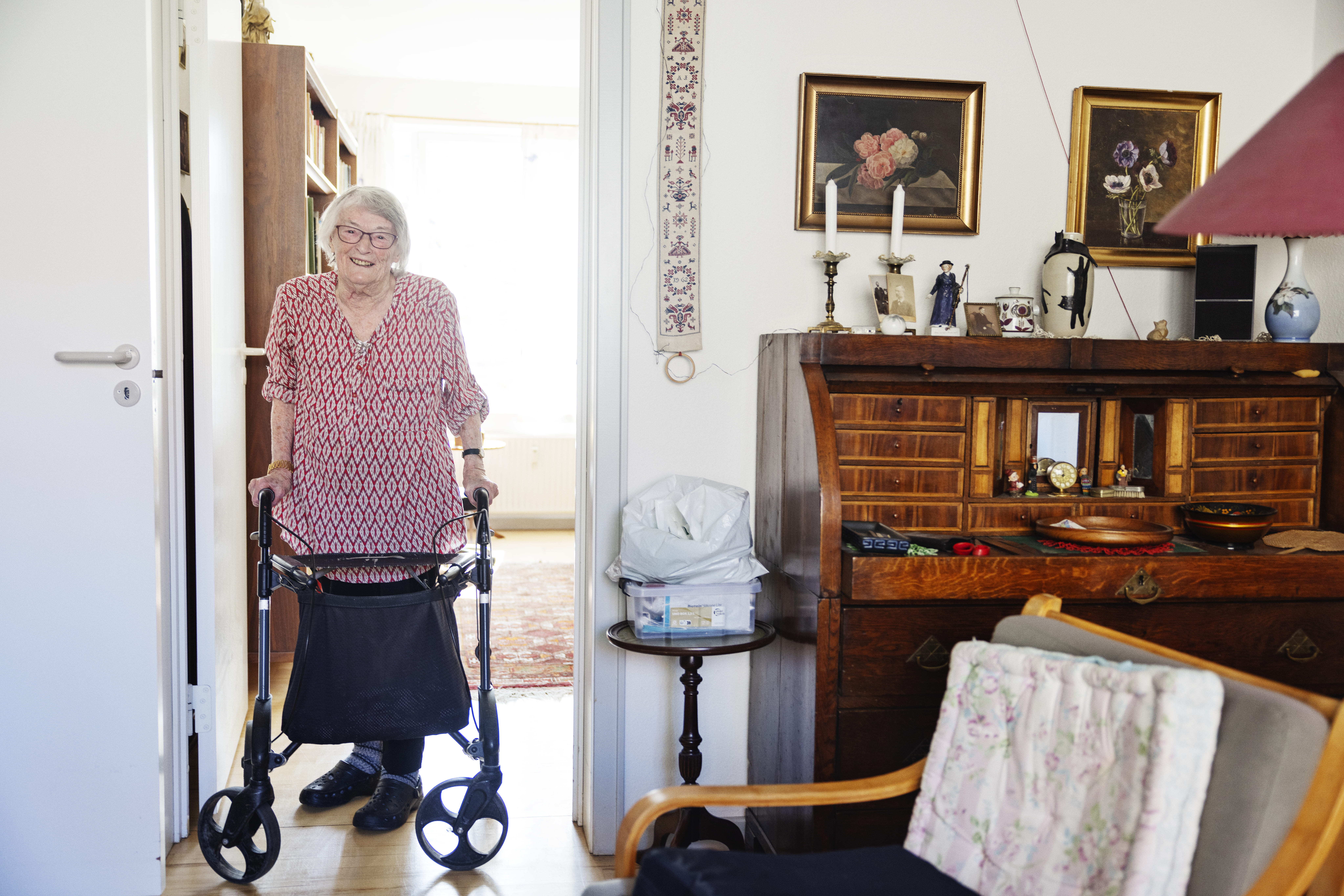 Anna Margrete Jensen staar med rollator i sin stue