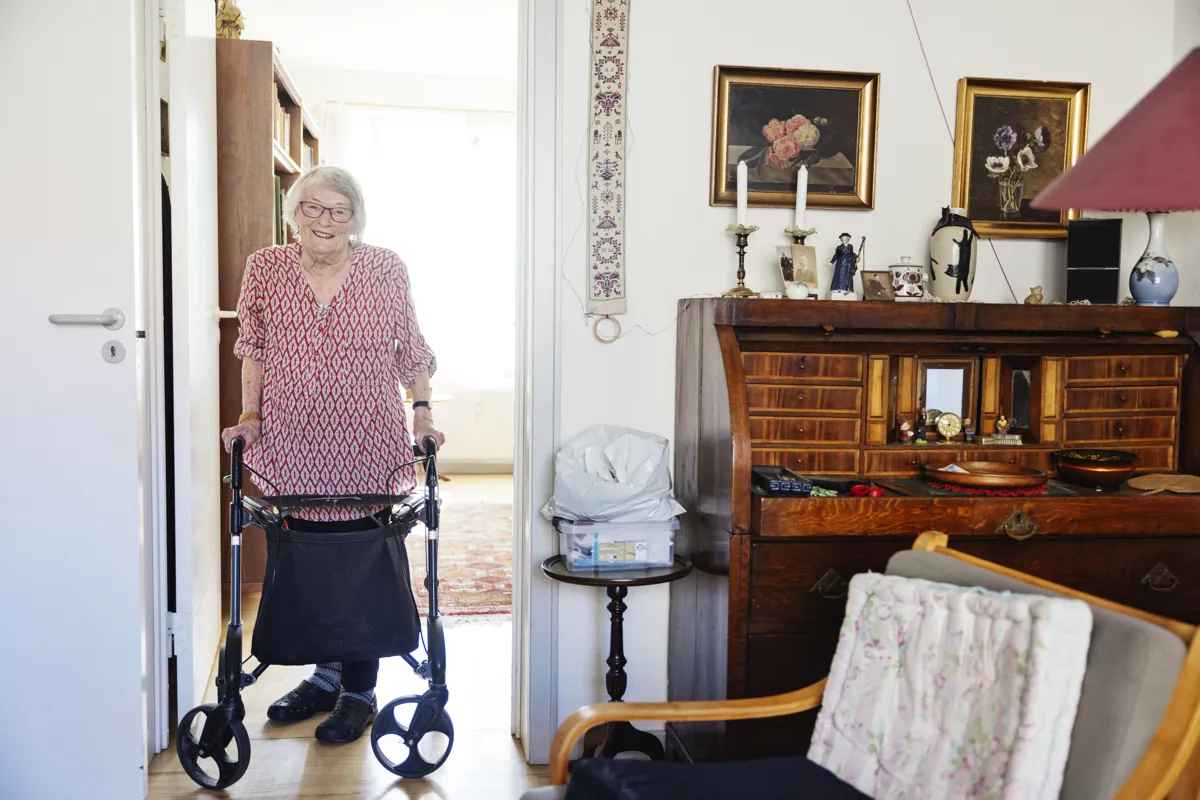 Anna Margrete Jensen staar med rollator i sin stue