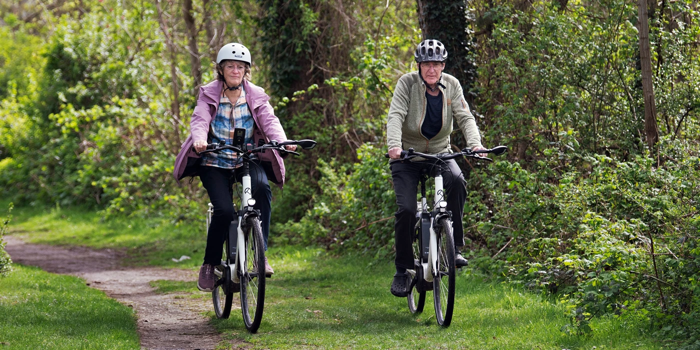 Mand og kvinde cykler i skoven